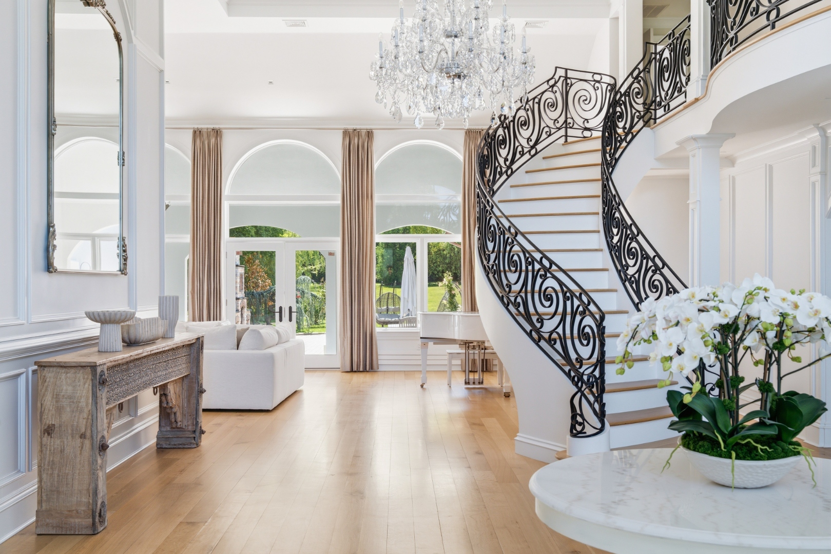 Soaring foyer with crystal chandeliers and curved staircase