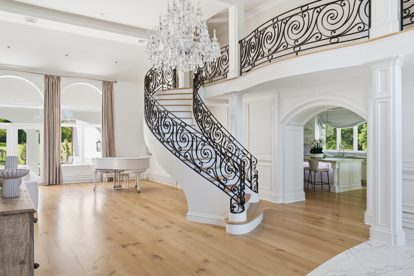 Foyer — curved staircase with ornate iron railings