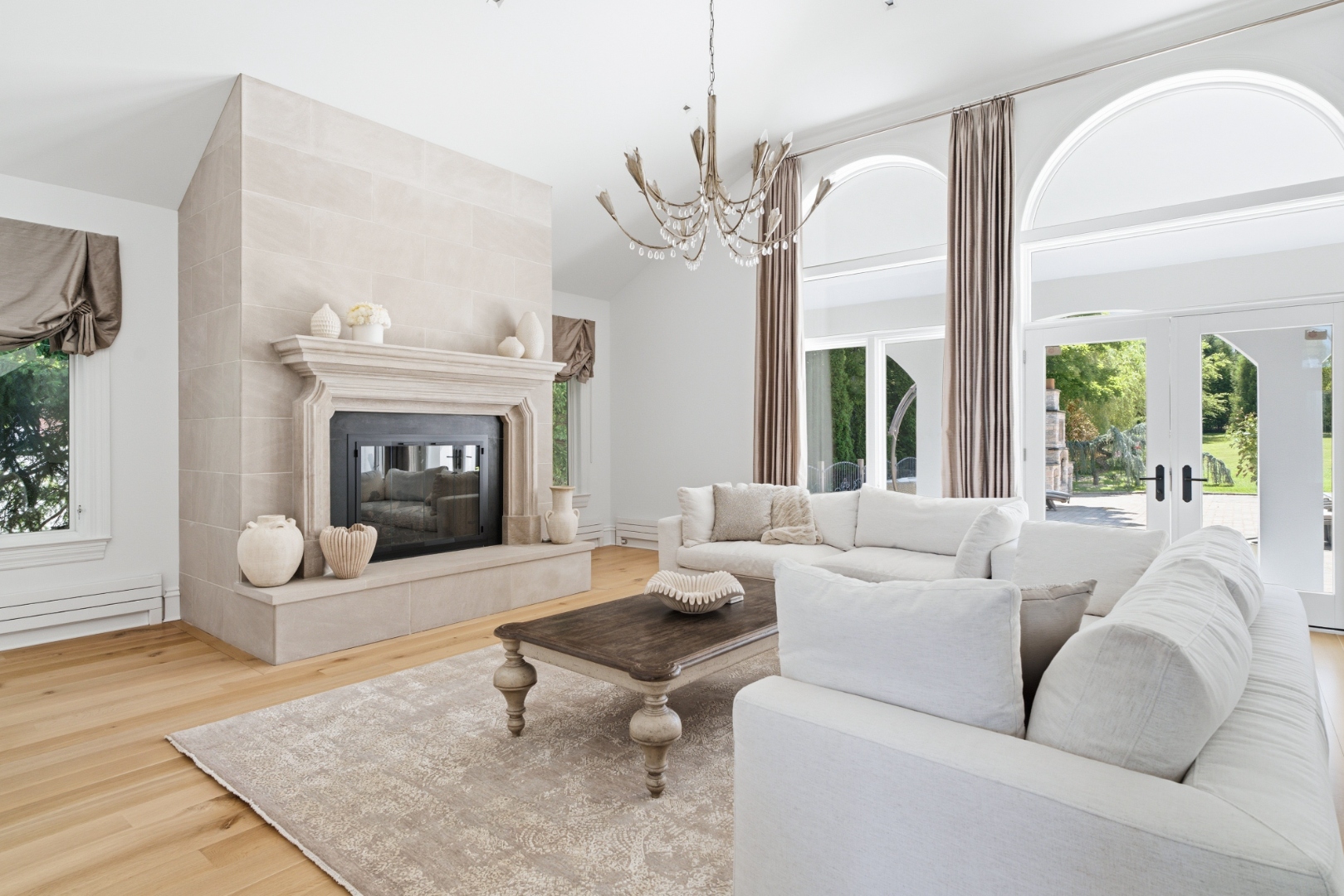 Living room with limestone fireplace and arched windows